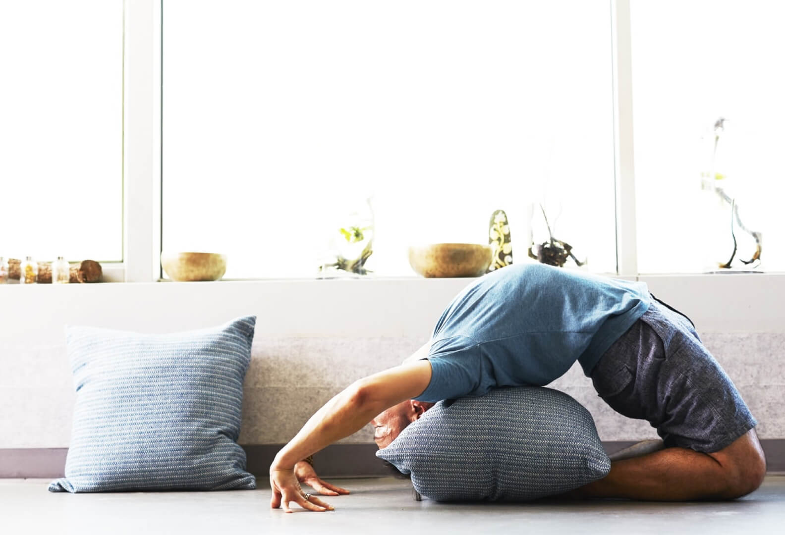 A man stretches back deeply onto a pillow.