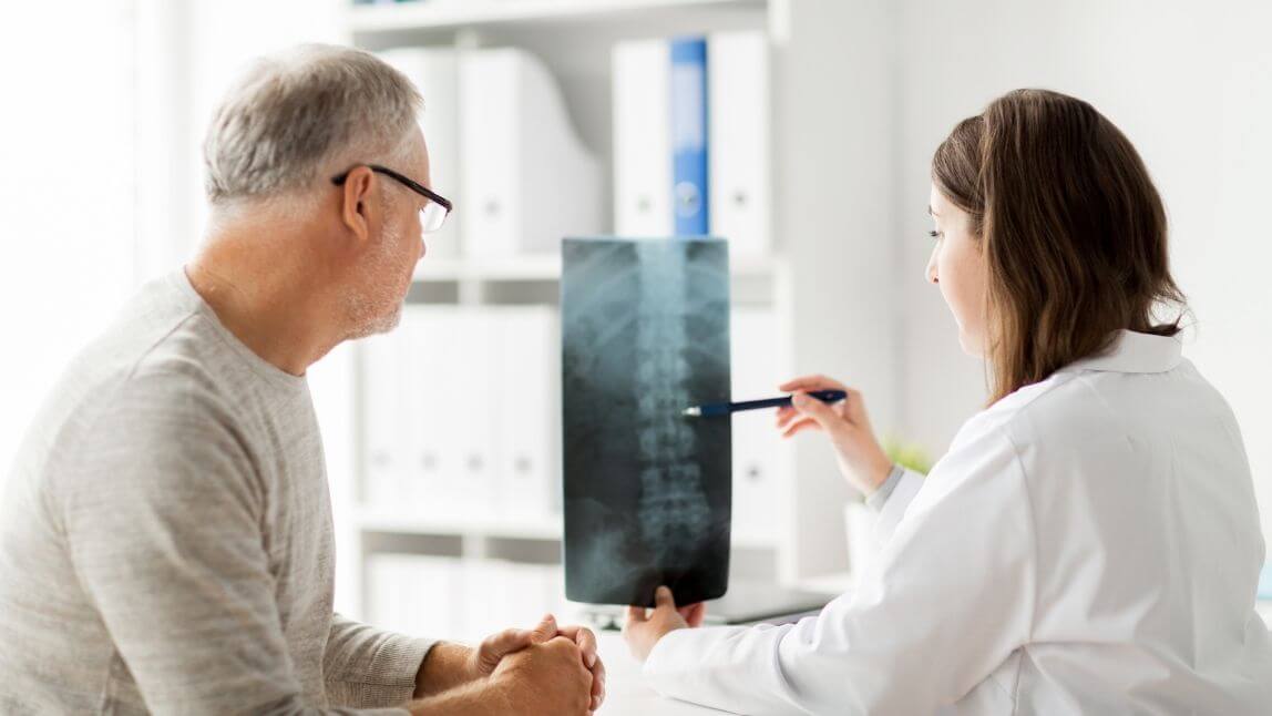 Ärztin erklärt Mann Röntgenbild